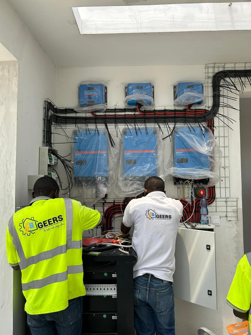 GEERS technicians wiring a Victron inverter bank on a site in Kinshasa