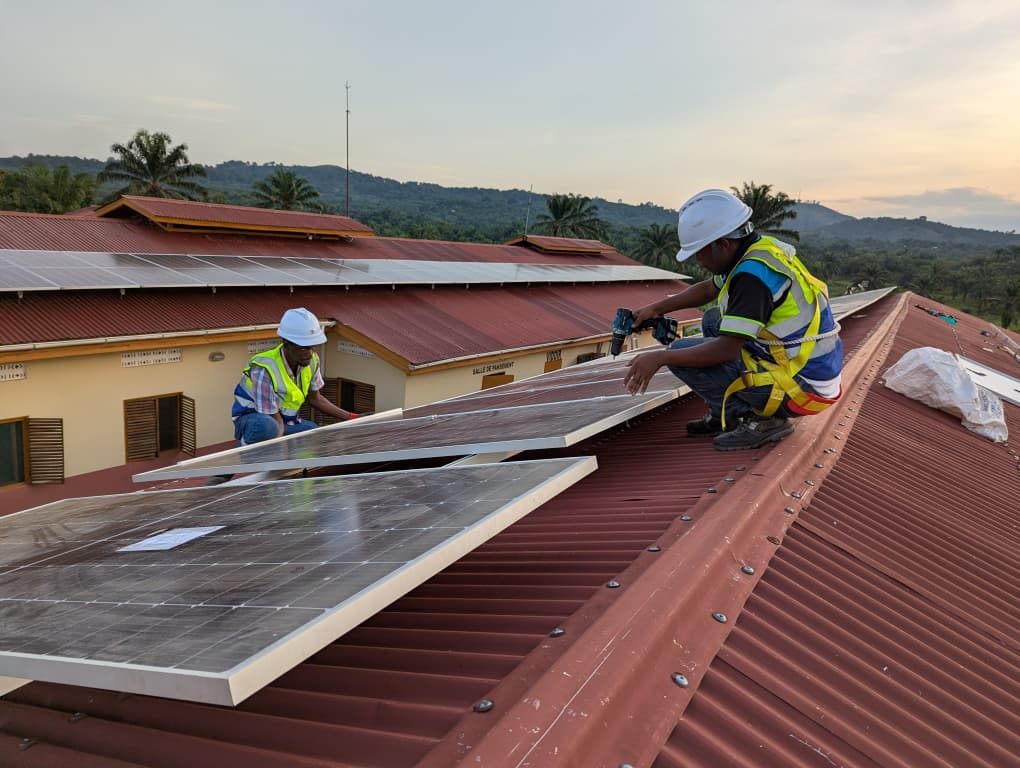 GEERS technicians fitting solar panels on a metal roof