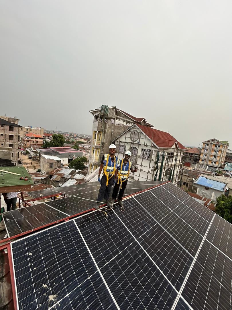 Techniciens GEERS posant des panneaux solaires sur une toiture à Kinshasa